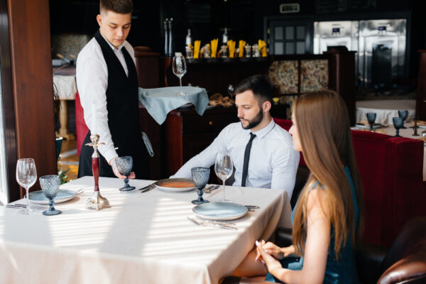 Chelner servește un cuplu la restaurant elegant