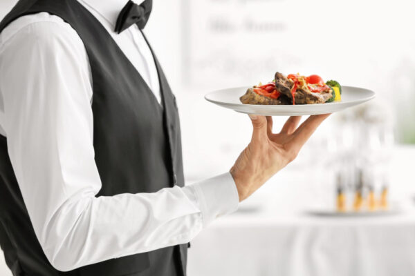 Chelner servind farfurie cu preparat gourmet