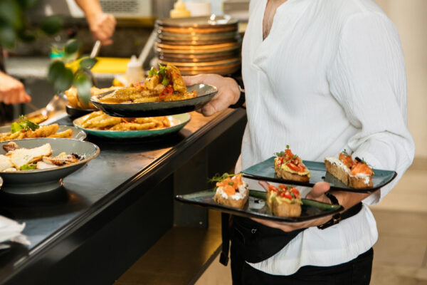 Ospătar ținând platouri cu aperitive în restaurant