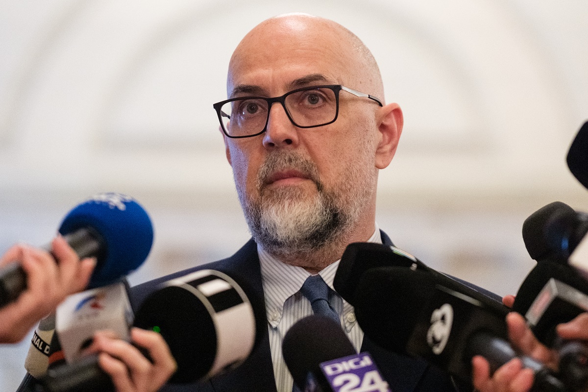 Bărbat chel cu ochelari, la conferință de presă