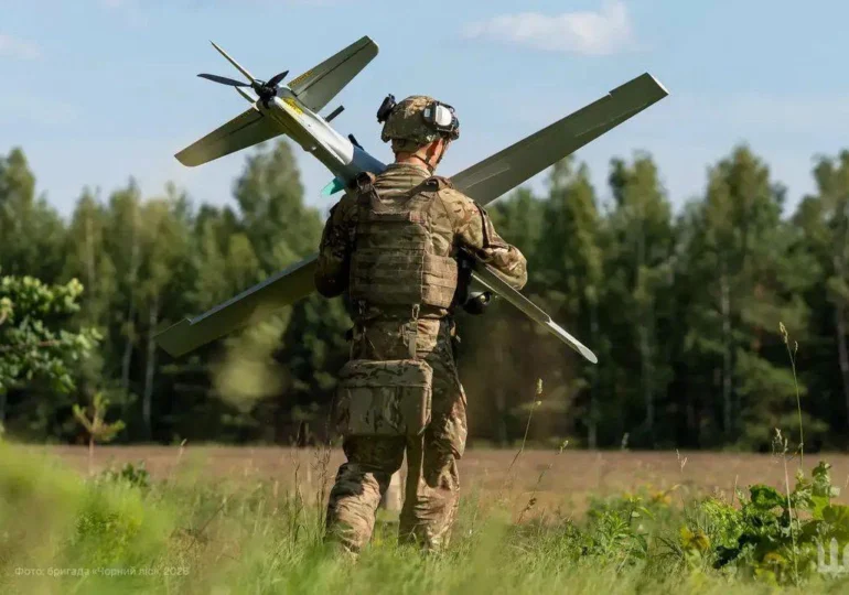 Soldat transportând dronă militară pe câmp
