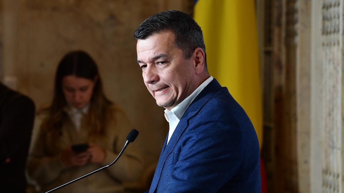 Bărbat în costum vorbind la pupitru oficial
