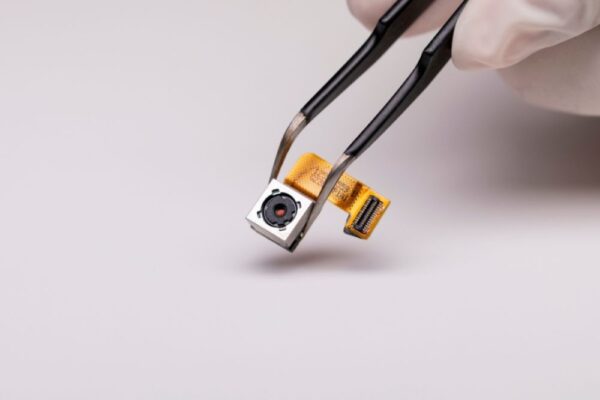 Modul cameră smartphone ținut cu pensetă
