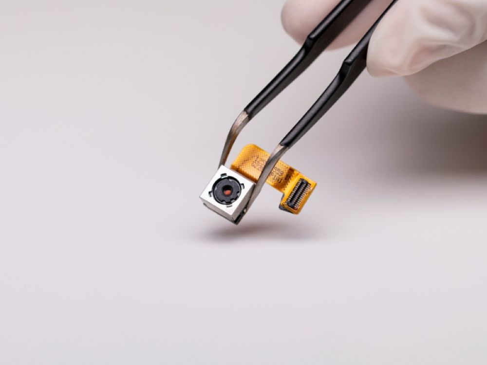 Modul cameră smartphone ținut cu pensetă