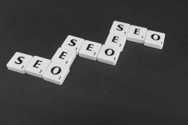 Piese Scrabble formând cuvântul SEO pe fundal închis
